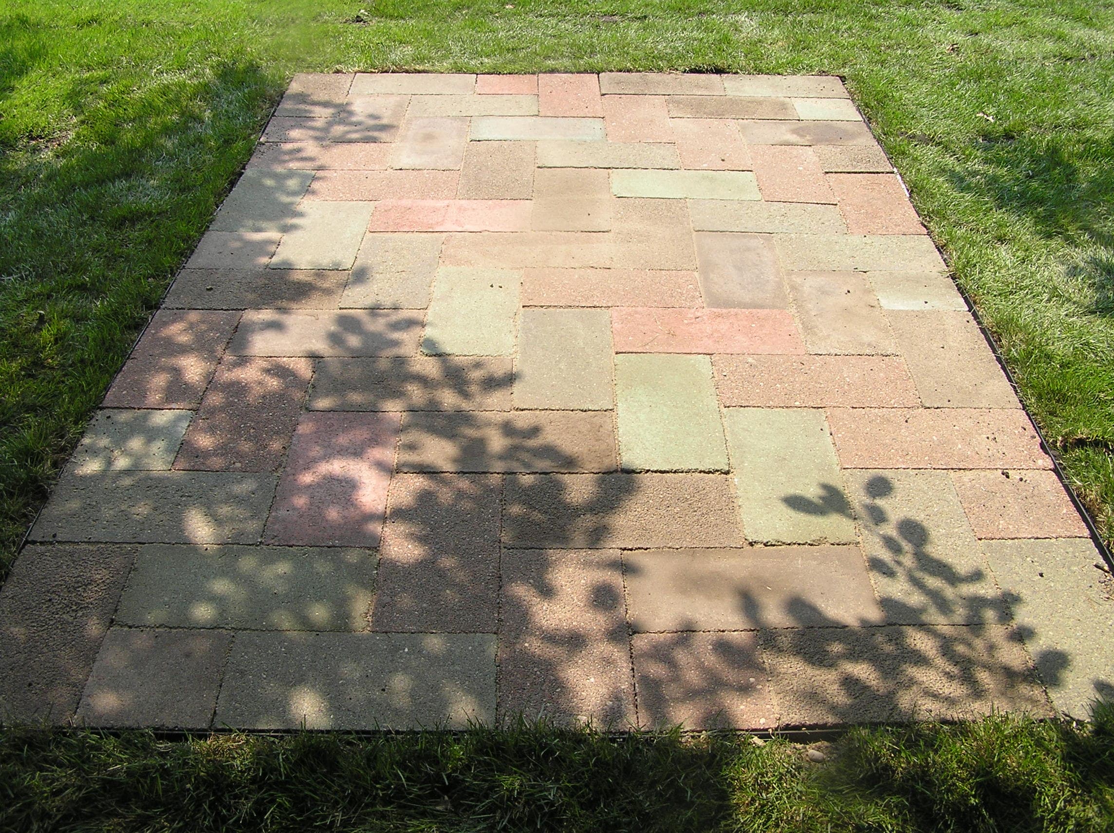 Stone paver patio surrounded by grass